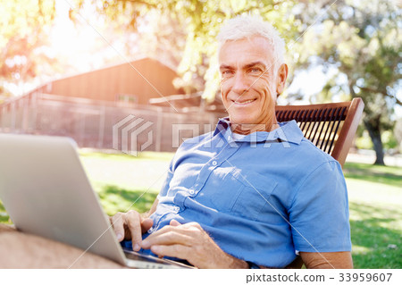 Senior man with notebook sitting in the park 33959607