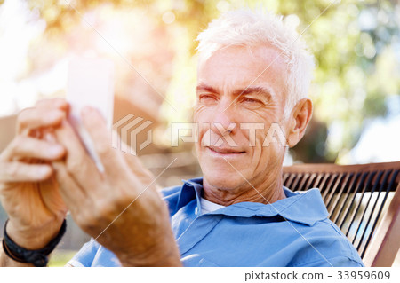 LoMature man outdoors using mobile phone 33959609