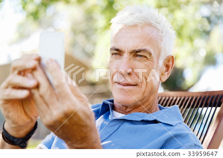 LoMature man outdoors using mobile phone 33959647