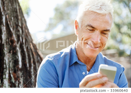 LoMature man outdoors using mobile phone 33960640