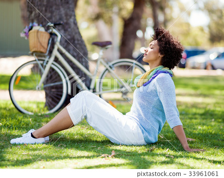 Beautiful woman sitting in summer park 33961061