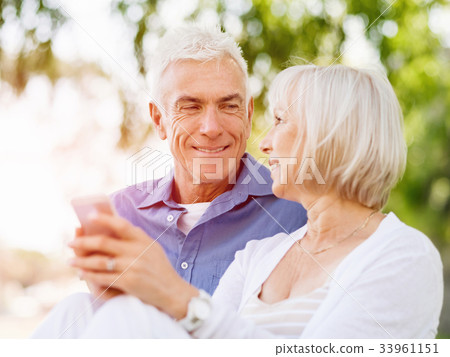 Happy senior couple looking at smartphone Happy senior couple looking at smartphone 33961151