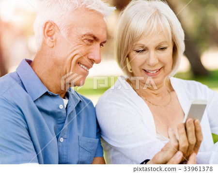 Happy senior couple looking at smartphone Happy senior couple looking at smartphone 33961378