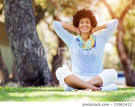 Beautiful woman sitting in summer park Beautiful woman sitting in summer park 33961412