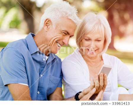 Happy senior couple looking at smartphone Happy senior couple looking at smartphone 33961413