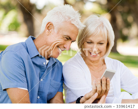 Happy senior couple looking at smartphone Happy senior couple looking at smartphone 33961417