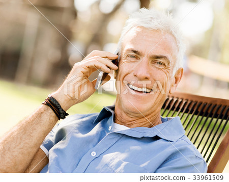 LoMature man outdoors using mobile phone LoMature man outdoors using mobile phone 33961509
