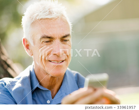 LoMature man outdoors using mobile phone LoMature man outdoors using mobile phone 33961957