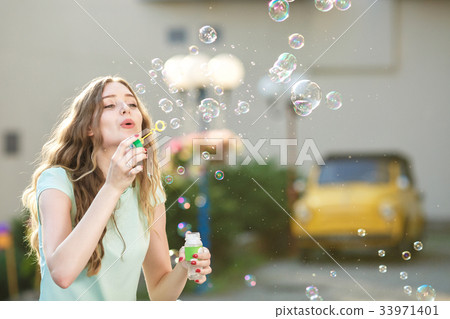 happy woman blowing soap bubbles happy woman blowing soap bubbles 33971401