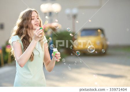 happy woman blowing soap bubbles happy woman blowing soap bubbles 33971404