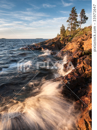 Surf on stony coast of lake with waves 33971647