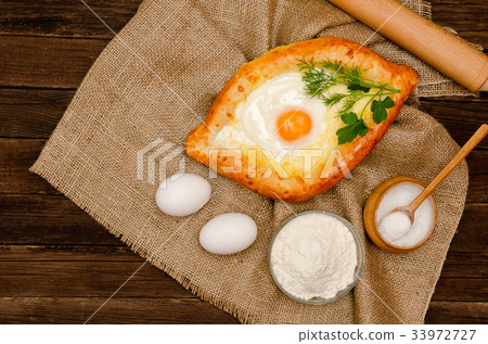 Khachapuri with eggs on sackcloth, salt, flour 33972727