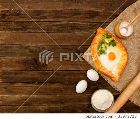 Khachapuri with eggs on sackcloth, salt, flour 33972728