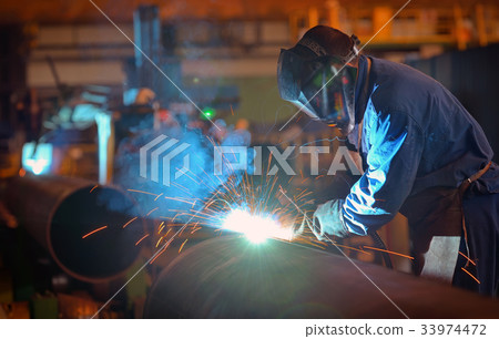 Welder performs welding large diameter pipe 33974472