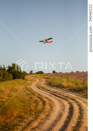 Small plane flies over country road and lavender 34046522