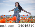 Woman in patterned sundress on flower field 34046810