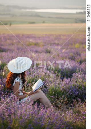 Romantic woman with book on lavender field Romantic woman with book on lavender field 34046825