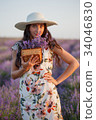 Woman with bunch of lavender in wicker basket 34046830