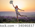 Smiling woman posing on one leg on lavender sunset 34046837