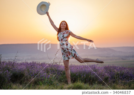Smiling woman posing on one leg on lavender sunset Smiling woman posing on one leg on lavender sunset 34046837