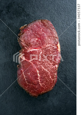 Dry aged raw Wagyu Point Steak as close-up on a sl Dry aged raw Wagyu Point Steak as close-up on a sl 34057337