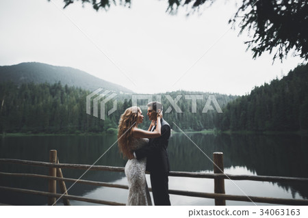 Perfect couple bride, groom posing and kissing in 34063163