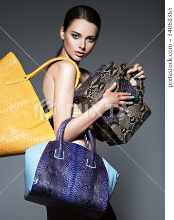 Beautiful naked woman holds fashion handbags Beautiful naked woman holds fashion handbags 34068365
