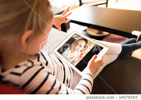 Little girl at home with tablet, video chatting 34076565