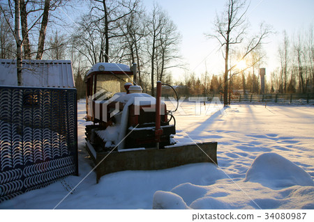 Tractor in the parking lot covered with snow 34080987