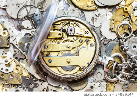 open vintage pocket watch on heap of spare parts 34089144