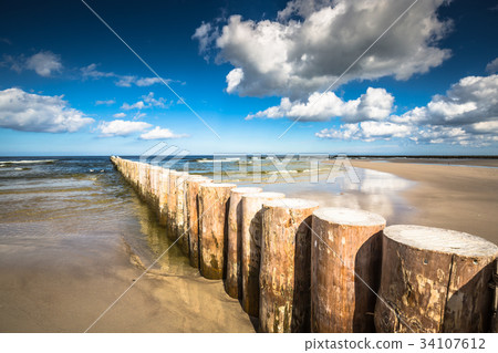 Wooden breakwaters on sandy Leba beach Wooden breakwaters on sandy Leba beach 34107612
