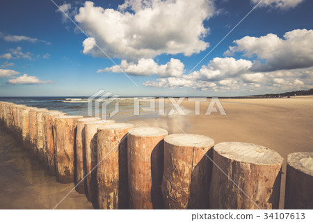 Wooden breakwaters on sandy Leba beach 34107613