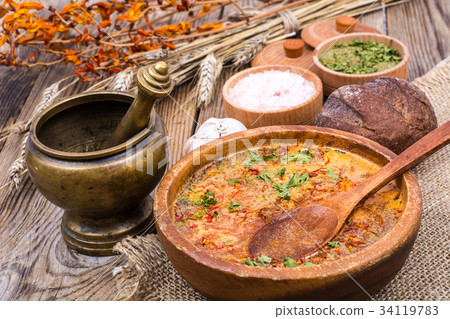 Village soup in wooden bowl on an old table 34119783