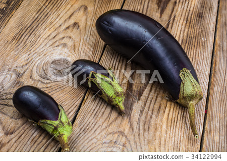 One large and two small eggplant on wooden One large and two small eggplant on wooden 34122994