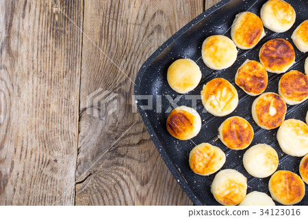 Sweet little fried cheesecakes in frying pan 34123016