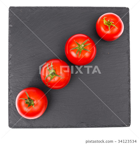 Ripe red tomatoes on black stone plate Ripe red tomatoes on black stone plate 34123534