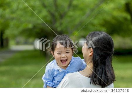 Mother and daughter playing in a fresh green park 34137948