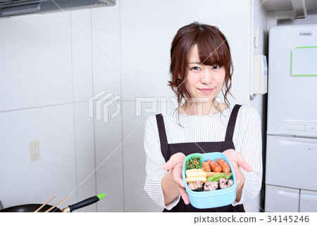 準備午餐的婦女在廚房裡 準備午餐的婦女在廚房裡 34145246