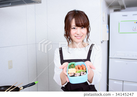 準備午餐的婦女在廚房裡 準備午餐的婦女在廚房裡 34145247