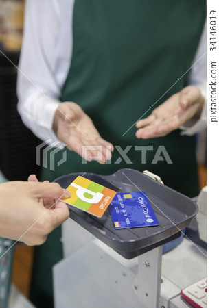 Woman using point card and credit card at super cash register 34146019