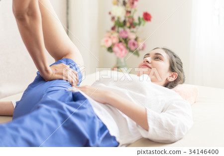 Women getting leg stretch in Thai massage course 34146400