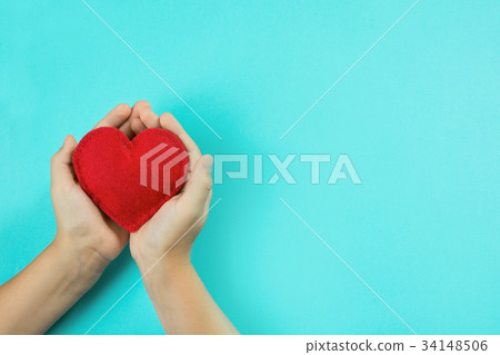 Red felt heart in childs hands on blue background. 34148506