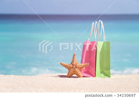 Shopping bags and starfish on sand 34150697