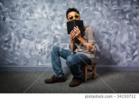 Hipster style asian man with book. Hipster style asian man with book. 34150712