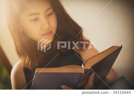 Asian woman reading a book vintage style. Asian woman reading a book vintage style. 34150844