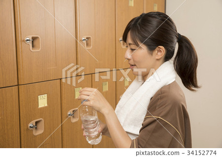 Woman doing hydration in the changing room of the spa facility Woman doing hydration in the changing room of the spa facility 34152774
