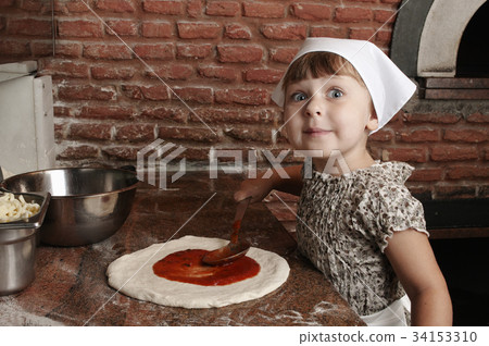 Adding tomato's sauce to pizza. Adding tomato's sauce to pizza. 34153310