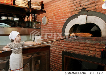 Baby baker getting out a bread from stove 34153334