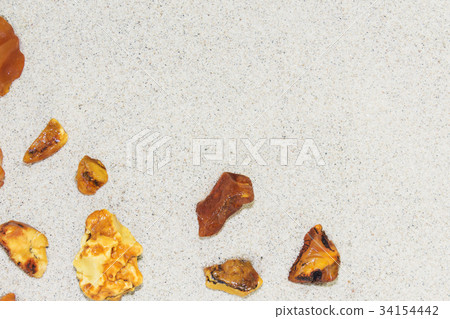 Amber. the pieces of amber in the sand on the 34154442