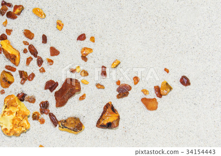 Amber. the pieces of amber in the sand on the 34154443